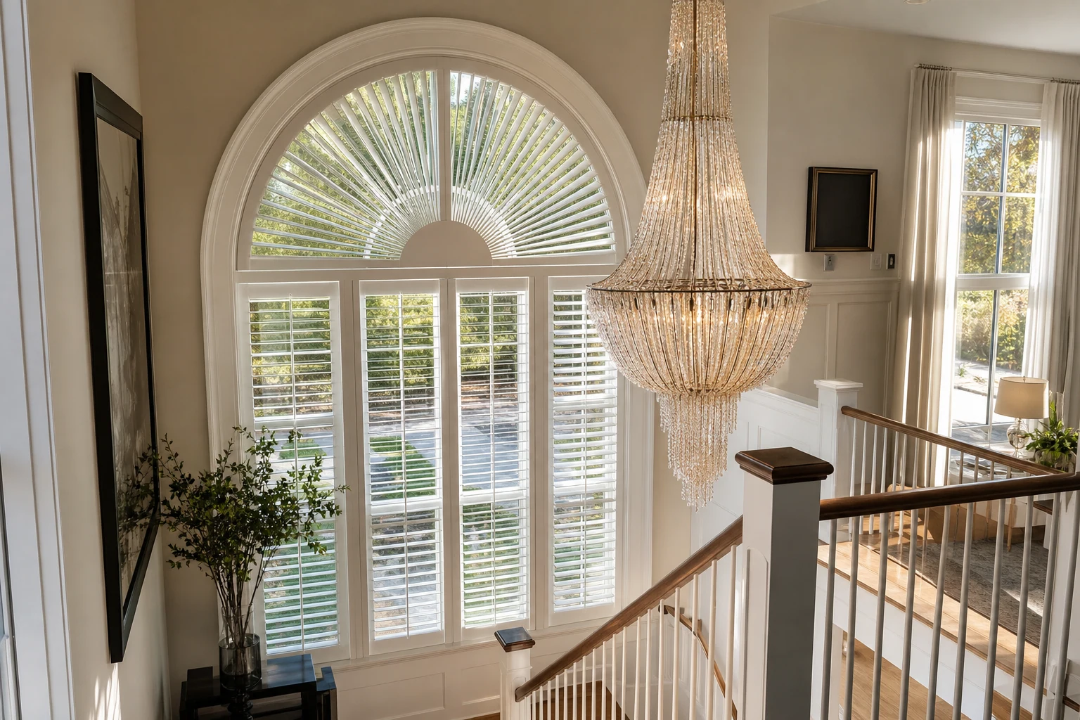 Custom arched palladium window with sunburst plantation shutters